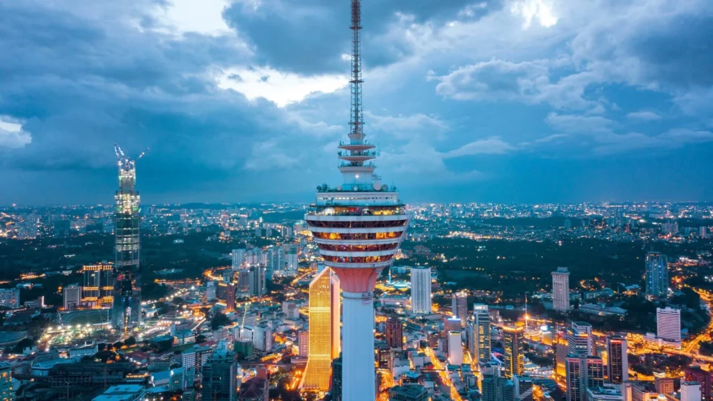 View of Menara Kuala Lumpur (KL Tower) at night, showcasing its bright lights and cityscape